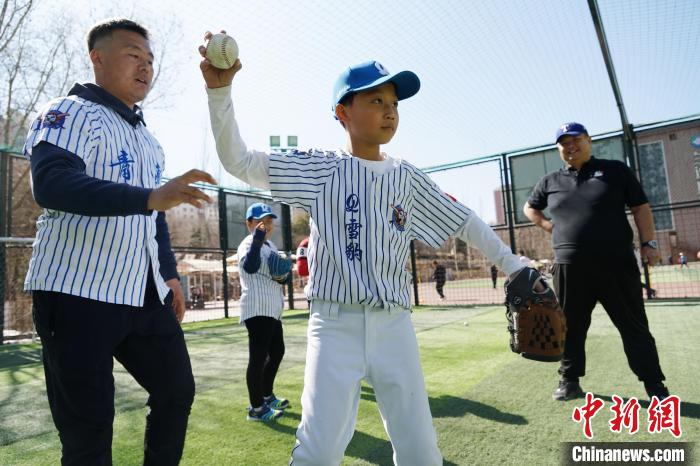 圖為教練指導(dǎo)小棒球手?jǐn)S球技術(shù)?！●R銘言 攝