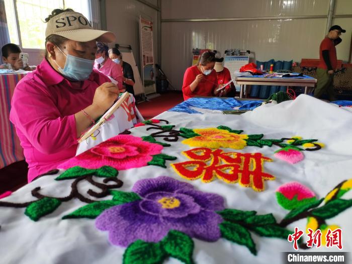 圖為婦女制作青繡?！?zhí)砀?攝