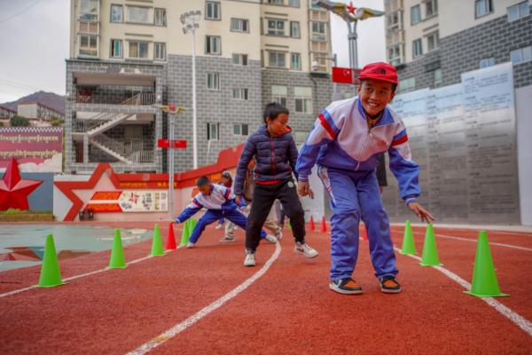 在高原上教孩子們打手球，“慢慢兒來，甭著急！”