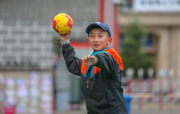 在高原上教孩子們打手球，“慢慢兒來，甭著急！”