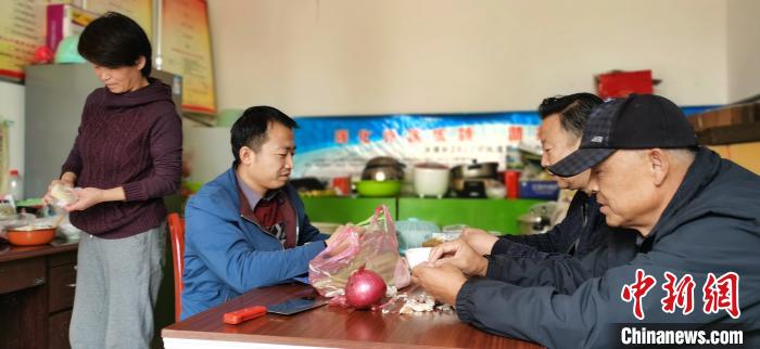 圖為扶貧路上“臨時(shí)一家人”準(zhǔn)備午餐?！∥航ㄜ?攝