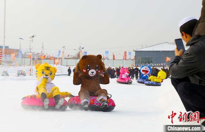 圖為臨夏市南龍鎮(zhèn)馬家莊村舉辦的鄉(xiāng)村文化旅游節(jié)上，游客穿著卡通服裝在體驗雪上飛碟項目。近年來，臨夏州形成了“春賞花、夏避暑、秋摘果、冬玩雪”的全季節(jié)旅游產(chǎn)品體系。(資料圖) 高展 攝