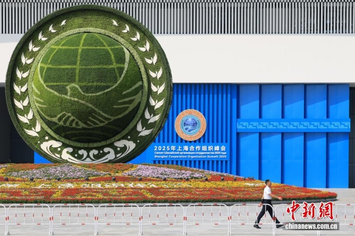 8月31日，天津，一名工作人員從2025年上海合作組織峰會主會場外的景觀花壇旁經(jīng)過。當(dāng)日，2025年上海合作組織峰會在天津舉行。<a target='_blank' href='/'><p  align=