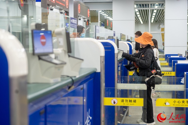 越南游客正在辦理入境手續(xù)。人民網(wǎng)記者 嚴(yán)立政攝