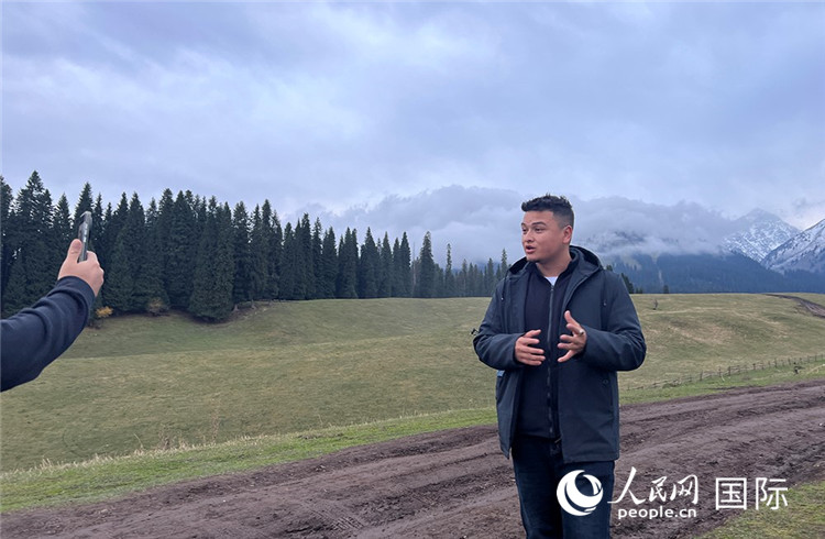 在庫爾德寧，吾買爾江被雪山美景震撼，即興錄制了短視頻作品。人民網(wǎng)記者曾書柔攝