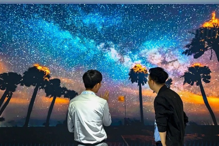 長春光博會希達電子展區(qū)，一位工作人員正在給一位觀眾講解。（長春新區(qū)供圖）