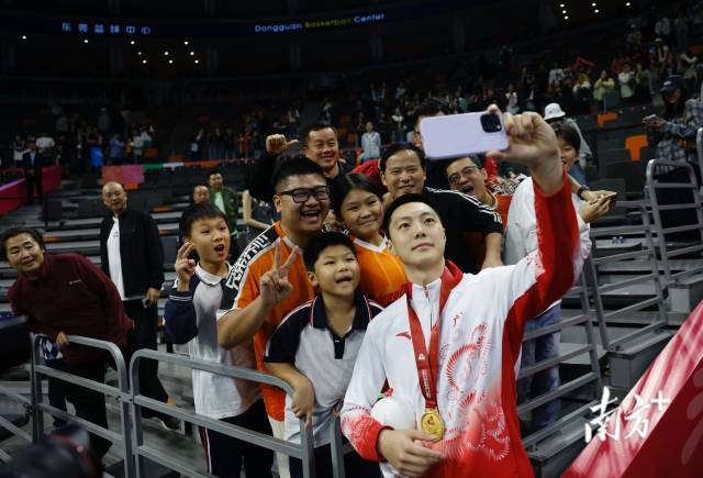 11月12日，十五運(yùn)會男籃成年組決賽，廣東隊(duì)獲得冠軍后，胡明軒與球迷們合影留念。張由瓊 攝