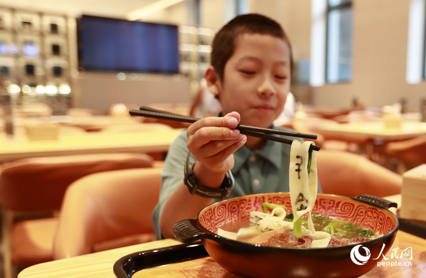 殷墟博物館推出的甲骨文面深受游客喜愛。人民網(wǎng)記者 慎志遠(yuǎn) 攝