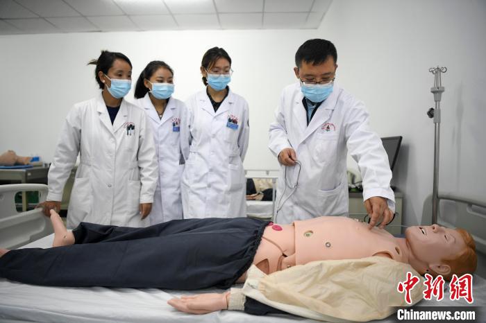 湖南中醫(yī)藥大學第一附屬醫(yī)院腦病科援藏醫(yī)生高曉峰(右一)為學生們進行體格檢查教學?！钊A峰 攝