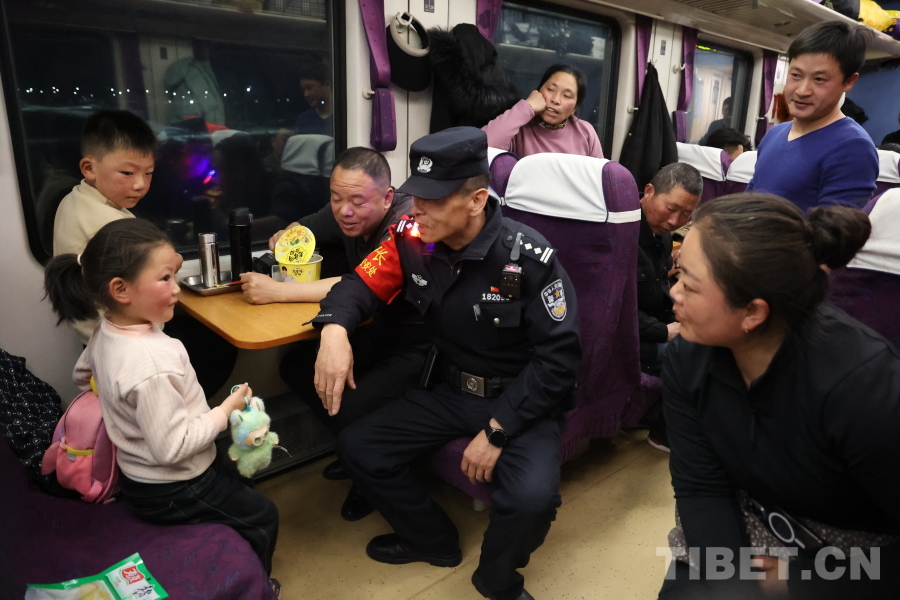 乘警長左紅彬在巡視車廂間隙，向攜帶兒童的旅客專門叮囑安全注意事項。.JPG