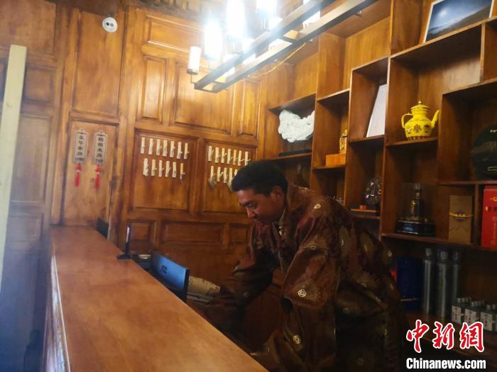 圖為桑杰才讓用電腦處理財務?！∈缝o靜 攝