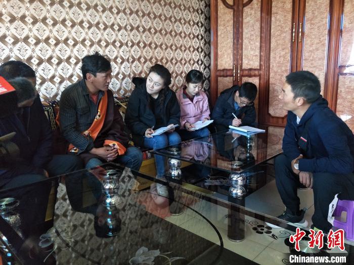 圖為調(diào)查組工作人員正在入戶調(diào)查?！∑钤鲚?攝