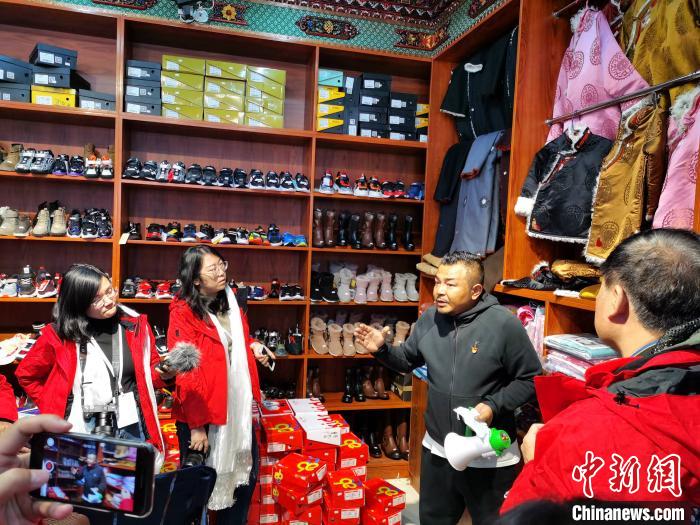 圖為中外媒體在玉樹州玉樹市甘達(dá)村采訪?！?zhí)砀?攝