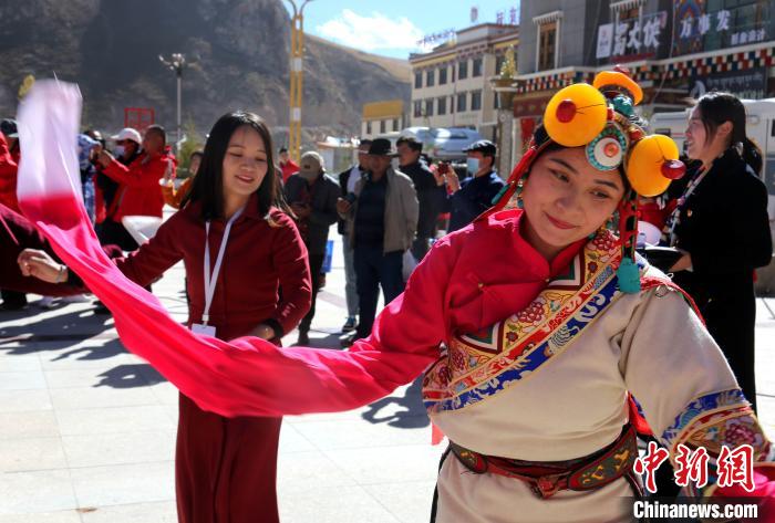 圖為中外記者向當?shù)孛癖妼W習民族歌舞文化。　張?zhí)砀?攝