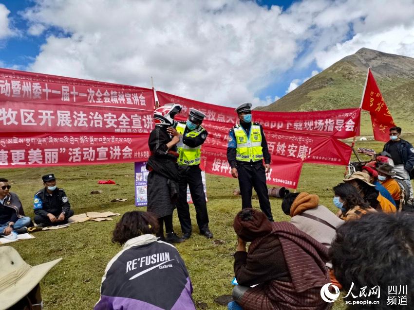 給牧民講如何佩戴安全頭盔。巴登攝