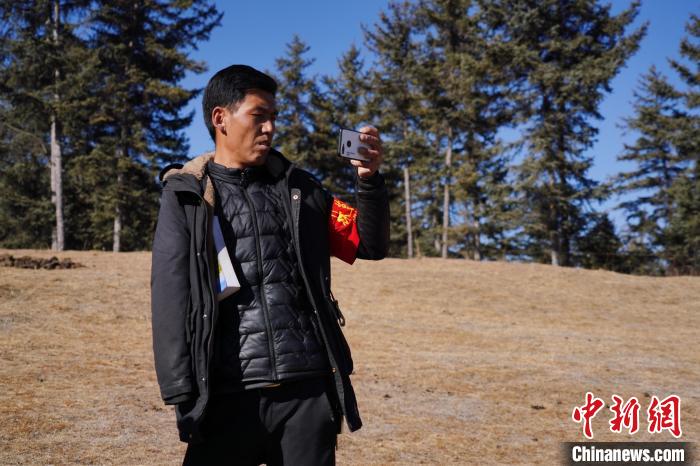 圖為桑杰加進(jìn)行巡查并拍照記錄。　馬銘言 攝