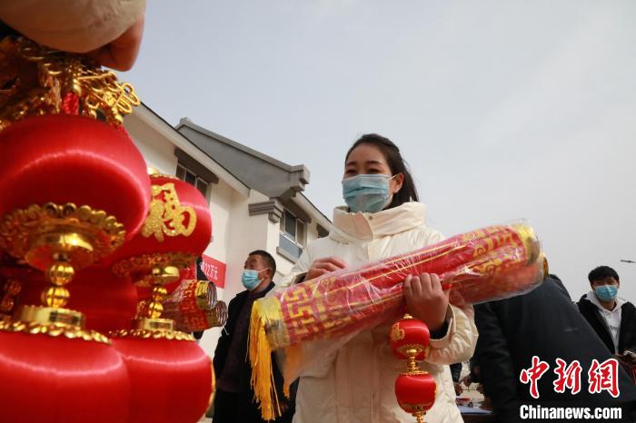 27日，蘭州新區(qū)為舟曲避險搬遷移民送“春節(jié)包”，楊周馬草前往領(lǐng)取，紅色寓意來年的日子紅紅火火?！∥航ㄜ?攝