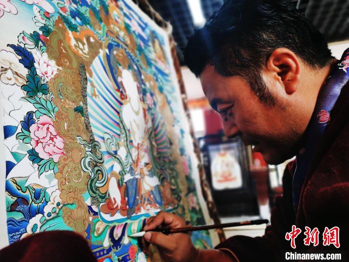 圖為久美尖措創(chuàng)作唐卡?！?zhí)砀?攝