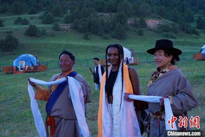 圖為當?shù)孛癖娕c外籍留學生合影留念?！●R銘言 攝