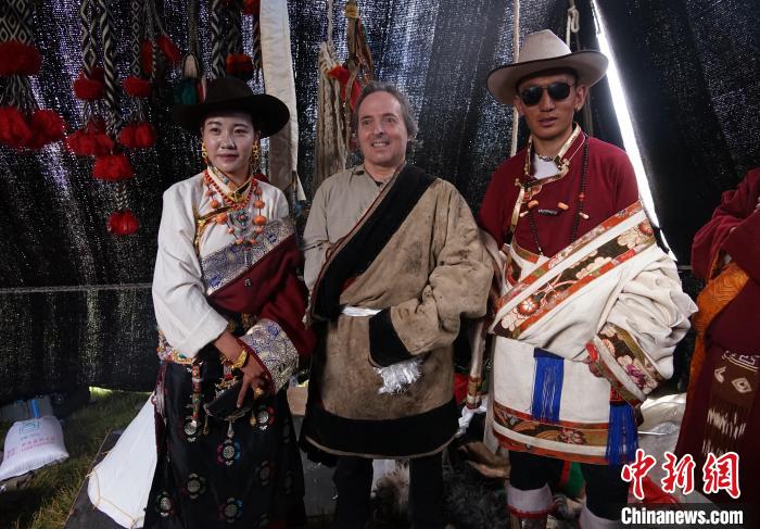 圖為一名外籍攝影師(中)身穿藏服和藏族民眾合影留念。　馬銘言 攝