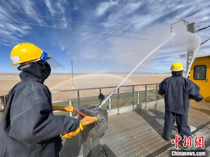 圖為水炮手操作高壓水槍對絕緣子進(jìn)行清洗。　高啟宏 攝