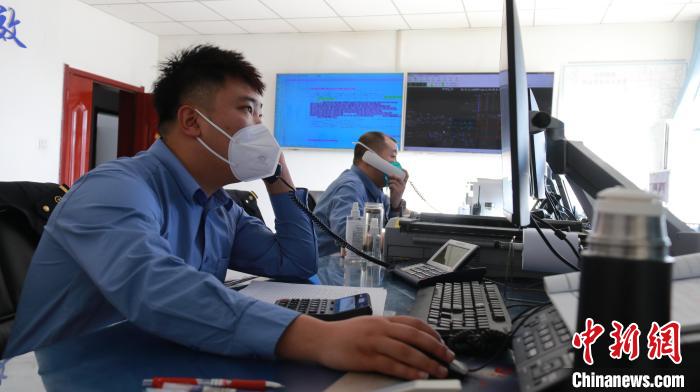 圖為貨運(yùn)調(diào)度人員與外勤工作人員聯(lián)系掌握車輛裝載情況。　李生燕 攝