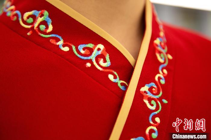 圖為新制服領(lǐng)口點綴有蒙古特色的烏力吉紋繡花?！±罾?攝