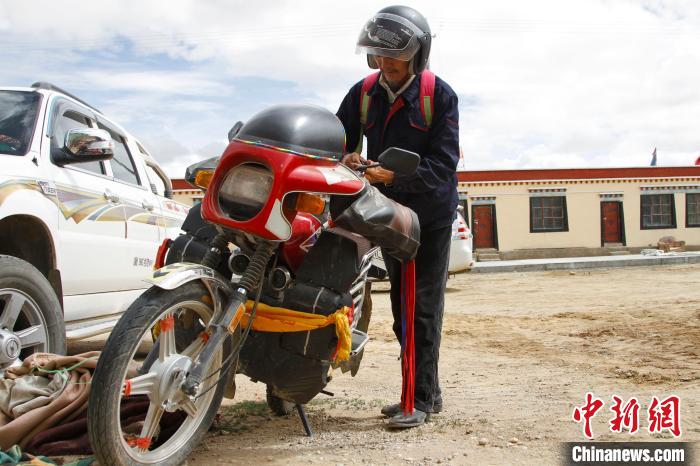 圖為白瑪準備騎摩托車巡湖。　趙朗 攝