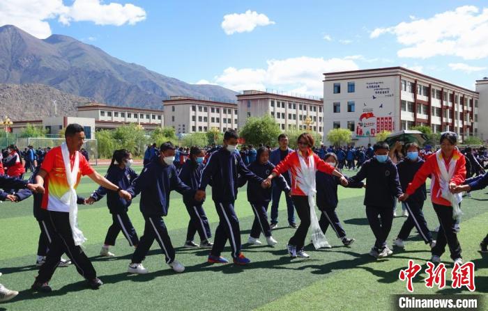 圖為世界冠軍與拉薩阿里地區(qū)高級中學學生一起跳鍋莊?！∪轿木?攝