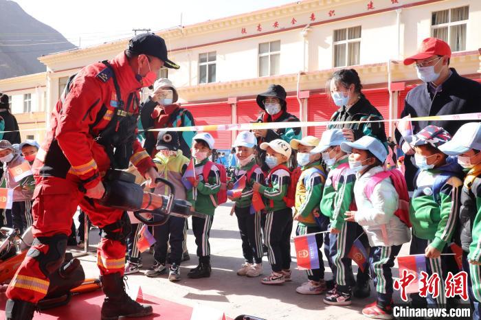 圖為消防指戰(zhàn)員為學(xué)生講解、演示先進(jìn)救援裝備?！≮w琳 攝