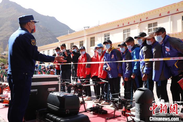 圖為消防指戰(zhàn)員為學(xué)生講解、演示先進(jìn)救援裝備?！≮w琳 攝