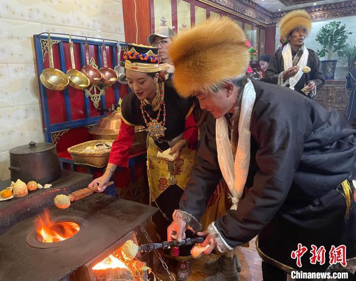 圖為人們?cè)诨鹕峡竟?jié)日美食“結(jié)達(dá)”。　冉文娟 攝