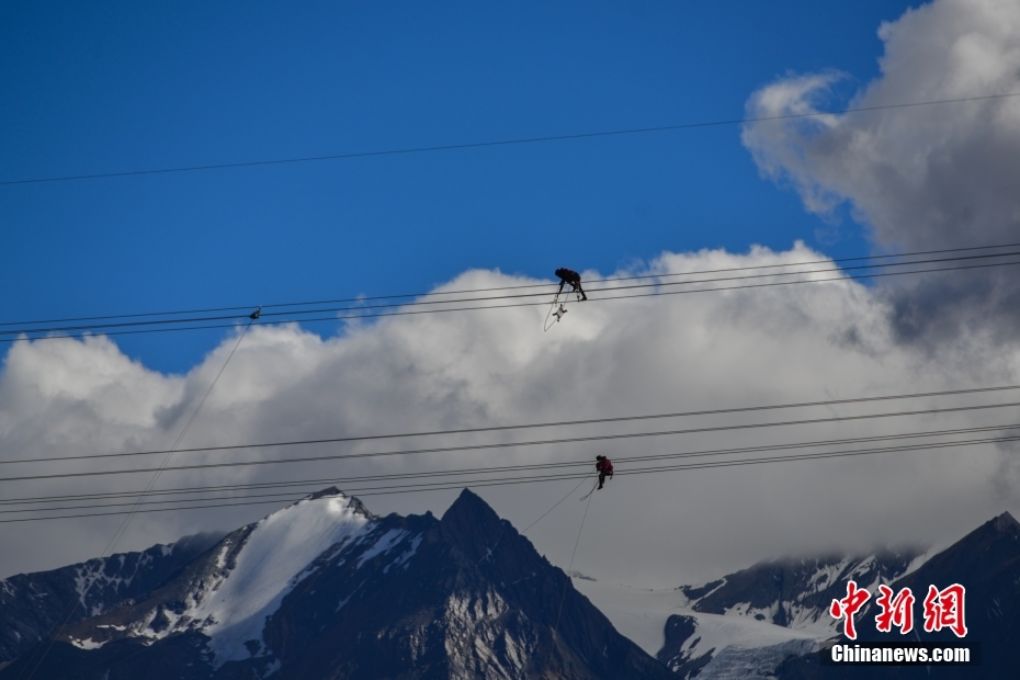 資料圖為2020年6月23日，西藏阿里聯(lián)網(wǎng)工程施工人員在日喀則希夏邦馬雪山附近進(jìn)行走線作業(yè)，安裝絕緣設(shè)備。 <a target='_blank' href='/'><p  align=