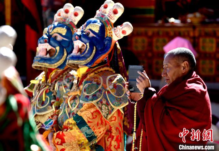 2月19日，正在拍攝跳神活動(dòng)的僧人。　李林 攝