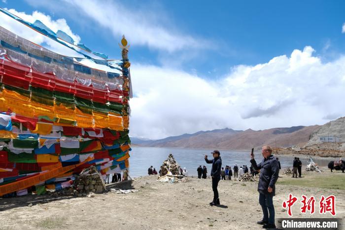 進(jìn)藏參訪嘉賓在羊湖畔拍攝經(jīng)幡?！〗w波 攝