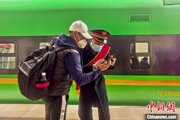 圖為日喀則火車站工作人員服務(wù)乘客。　斗山得 攝