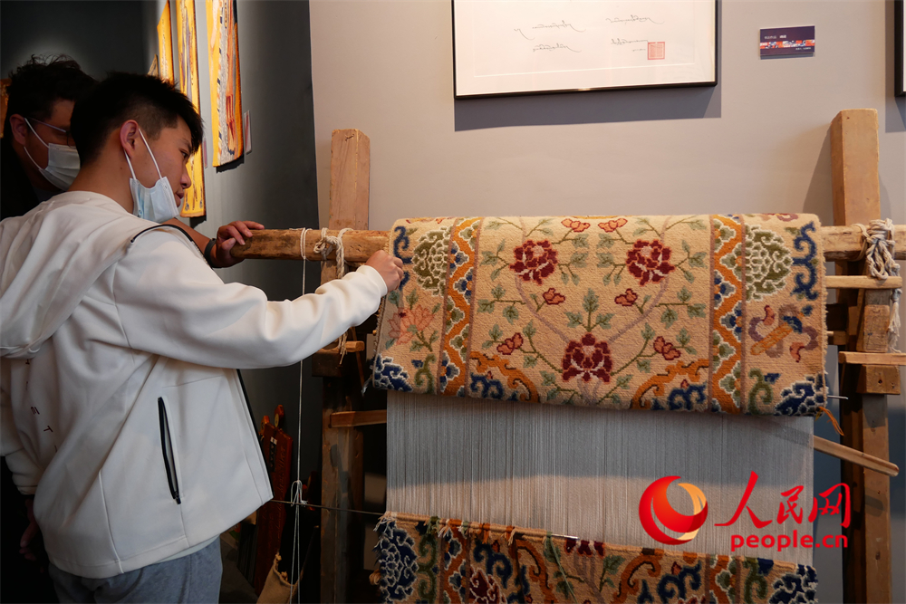 觀眾正在觀賞展出的藏毯。人民網(wǎng) 韋衍行攝