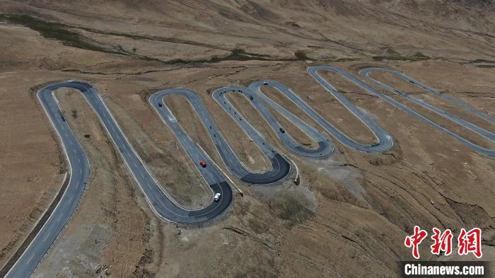 圖為騎手前往珠峰大本營(yíng)途經(jīng)108道拐?！∮文恋厍蚬﹫D