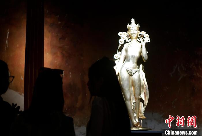 圖為觀眾正在欣賞展覽中的雕塑作品《八萬四千年》?！±盍?攝