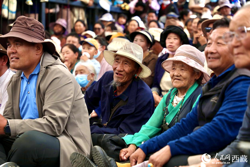 當(dāng)?shù)厝罕姾陀慰陀^看藏戲演出。