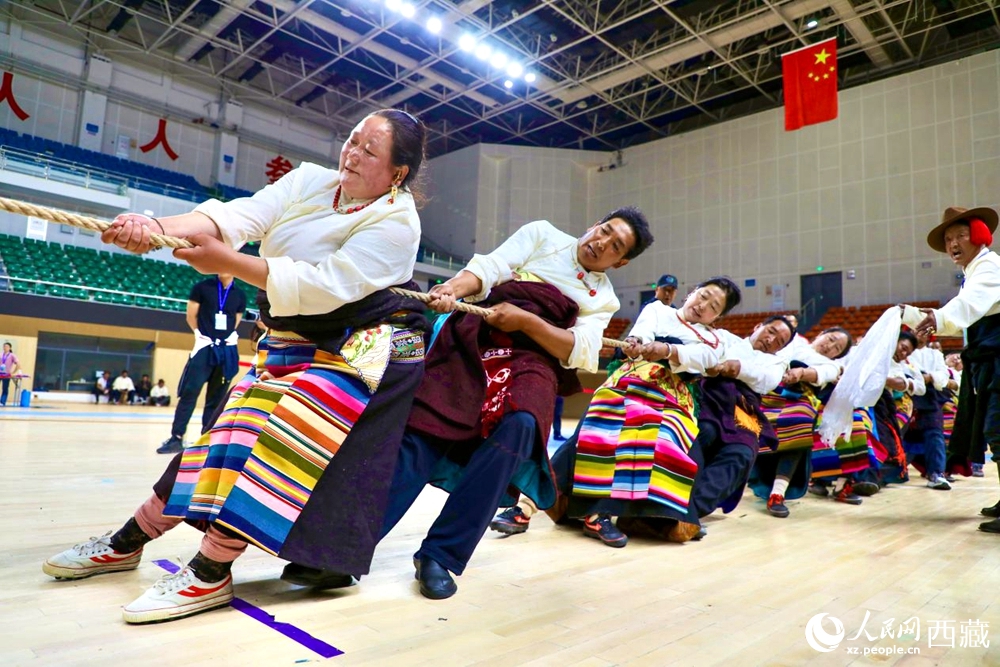 身著民族服裝的農(nóng)牧民選手在拔河比賽現(xiàn)場。