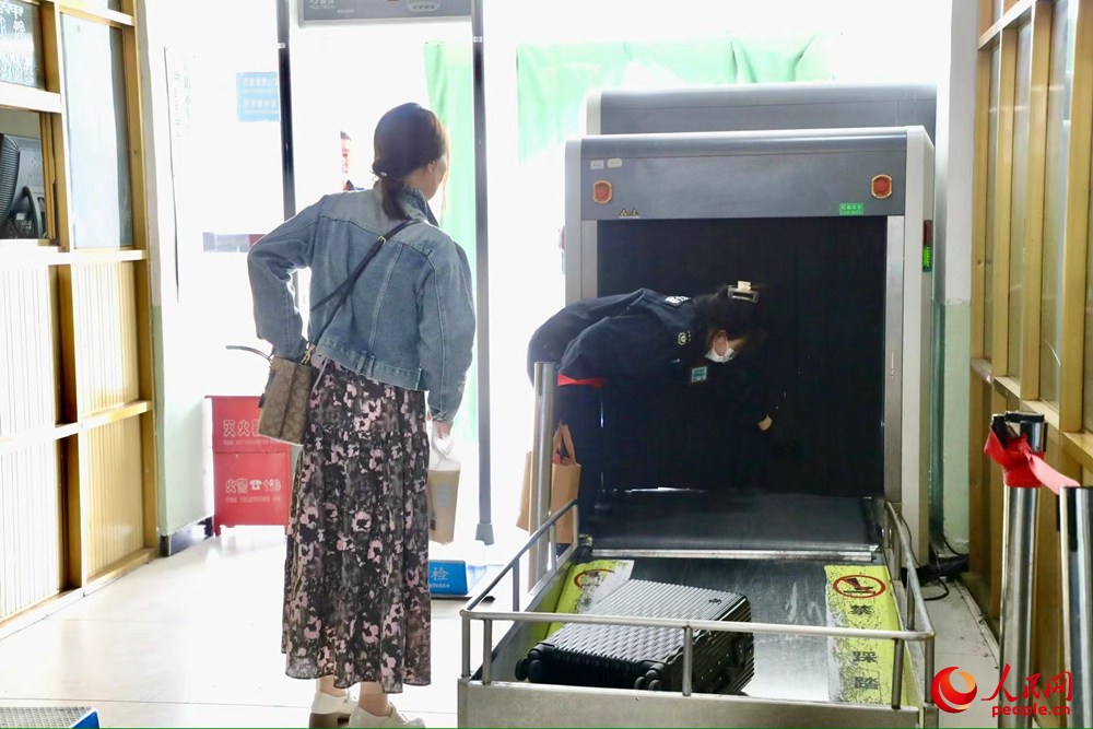 車站工作人員幫旅客提取行李。人民網(wǎng)記者 次仁羅布攝