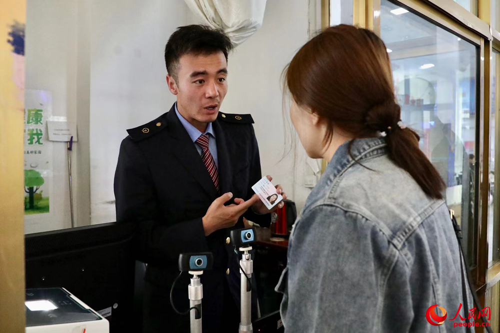 車站工作人員向旅客解答疑問。人民網(wǎng)記者 次仁羅布攝