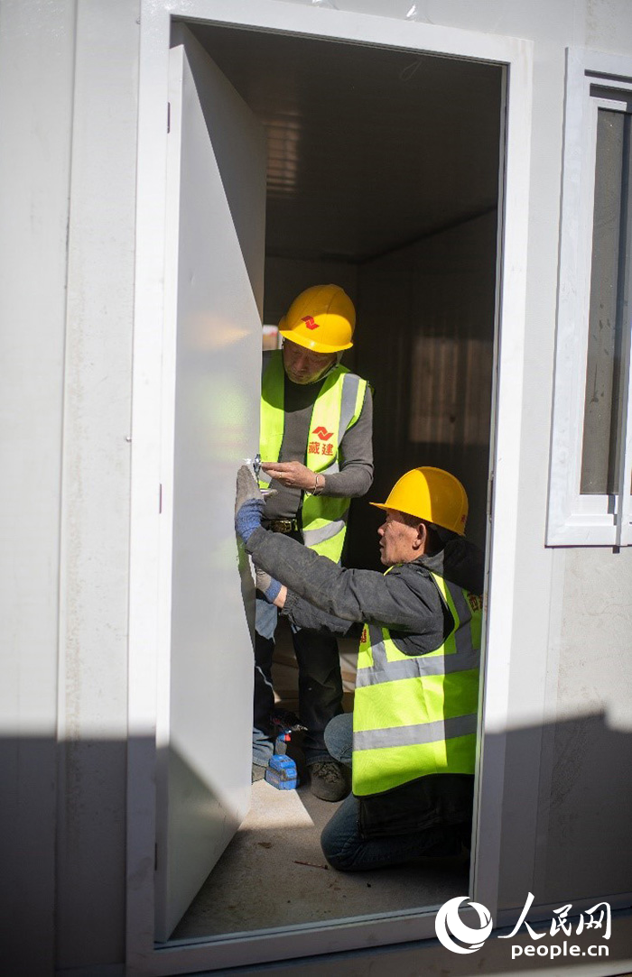 1月9日，在日喀則市定日縣長所鄉(xiāng)古榮村安置點(diǎn)，施工人員正在抓緊搭建移動(dòng)板房，確保受災(zāi)群眾溫暖過冬。人民網(wǎng)記者 翁奇羽攝