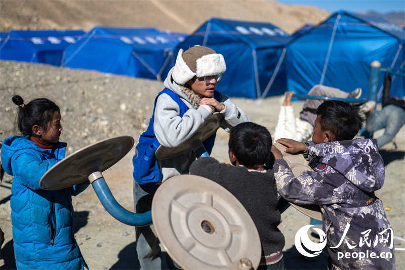 西藏星光社會工作服務中心社工久米旦增通過聊天談心，對孩子們進行災后心理疏導。人民網(wǎng)記者 翁奇羽攝