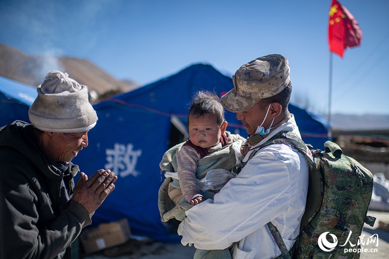 1月9日，在定日縣長所鄉(xiāng)古榮村安置點，受災(zāi)群眾感謝西藏軍區(qū)陸軍某部隊衛(wèi)生員的醫(yī)療救治。人民網(wǎng)記者 翁奇羽攝