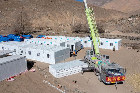 2025年1月9日，在定日縣長所鄉(xiāng)古榮村安置點，救援人員和施工人員合力抓緊搭建移動板房，確保受災(zāi)群眾溫暖過冬。人民網(wǎng)記者 翁奇羽攝
