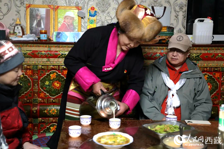扎西曲登社區(qū)的居民在家中熱情招待遠(yuǎn)道而來的游客。居民身著盛裝，為游客倒上熱騰騰的酥油茶，桌上擺放著切瑪與特色美食，賓主共話民族團結(jié)情誼。人民網(wǎng)記者 吳雨仁攝