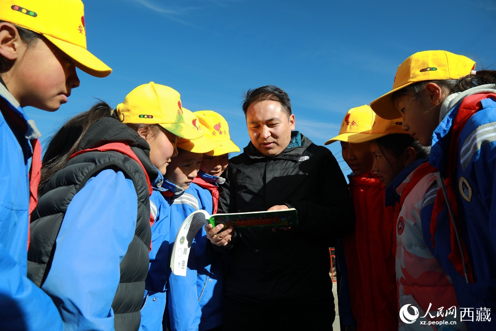 西藏自治區(qū)藏醫(yī)院專家為拉東村小學(xué)生講解天文歷算原理，孩子們圍站聆聽，感受傳統(tǒng)智慧與現(xiàn)代科普的融合。人民網(wǎng)記者 吳雨仁攝