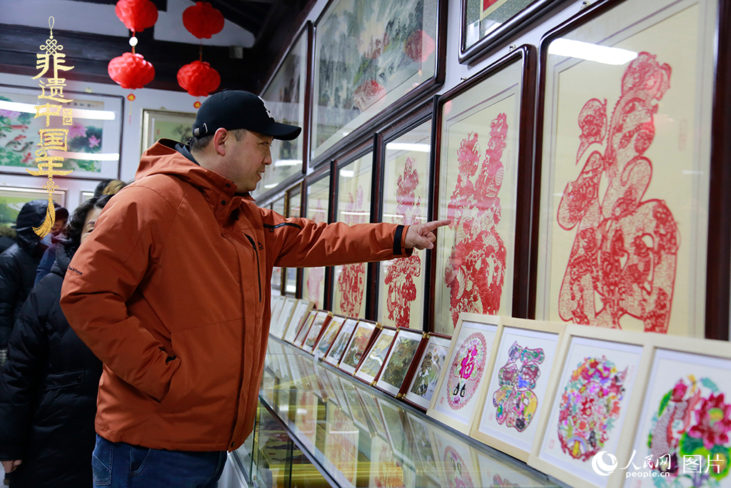 2025年1月23日，游客在天津楊柳青古鎮(zhèn)欣賞傳統(tǒng)剪紙作品，感受指尖上的古老藝術(shù)。人民網(wǎng)記者 崔新耀攝